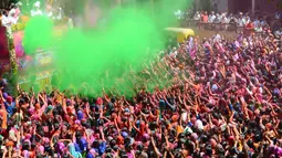 Umat Hindu India disemprot dengan cairan berwarna dalam festival Holi di Kuil Swupramayan Kalupur, Ahmedabad, Rabu (20/3). Holi juga menjadi libur nasional yang biasanya bertepatan dengan hari terakhir purnama dalam kalender Hindu. (SAM PANTHAKY / AFP)