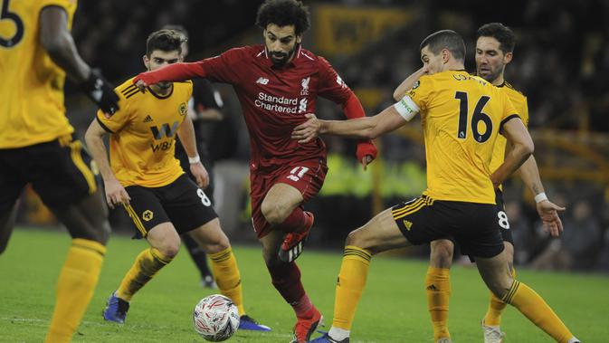 Penyerang Liverpool, Mohamed Salah, berusaha melewati pemain Wolverhampton Wanderers pada laga Piala FA di Stadion Molineux, Senin (7/1). Liverpool takluk 1-2 dari Wolverhampton Wanderers. (AP/Rui Vieira)