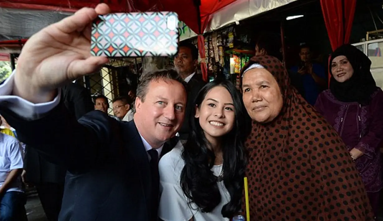 Maudy Ayunda selfie dengan David Cameron dan juga pemilik warung bernama bu Juna (via dailymail.co.uk)