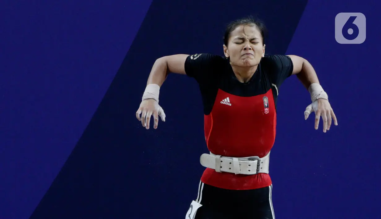 Lifter Windy Aisyah bersiap melakukan angkatan saat SEA Games 2019 cabang angkat besi nomor 49 kg di Stadion Rizal Memorial, Manila, Minggu (1/12/2019). Windy Aisyah meraih emas dengan total angkatan 104 kg. (Bola.com/M Iqbal Ichsan)