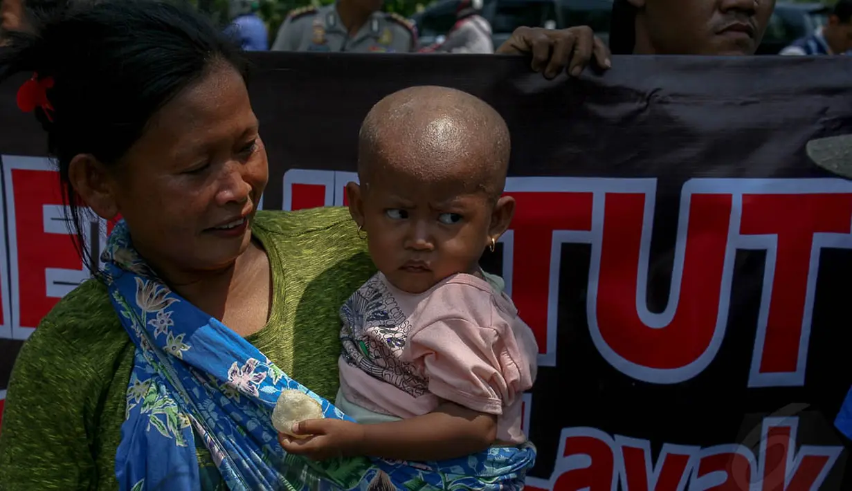 Di antara puluhan pengunjuk rasa, tampak seorang ibu menggendong anaknya yang masih kecil, Jakarta, (22/9/14). (Liputan6.com/Faizal Fanani)