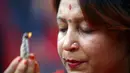 Seorang perempuan Hindu terlihat khusyuk berdoa di kuil Pashupatinath saat perayaan festival Teej di Kathmandu, (28/8/2014). (REUTERS/Navesh Chitrakar)