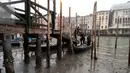 <p>Penumpang turun dari gondola yang berlabuh di sepanjang kanal saat air surut di Venesia, Italia, 21 Februari 2023. Beberapa kanal sekunder Venesia praktis mengering akhir-akhir ini akibat gelombang surut terkait dengan sistem cuaca bertekanan tinggi yang berkepanjangan. (AP Photo/Luigi Costantini)</p>