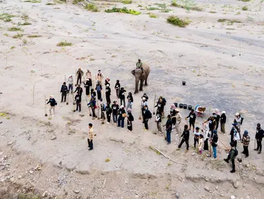 Relawan peduli lingkungan menanam pohon di Daerah Aliran Sungai (DAS) Peusangan, Negeri Antara, Bener Meriah, Aceh, Sabtu (18/7/2026). (AFP/ Chaideer Mahyuddin)
