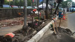 Pekerja menyelesaiakan proyek pelebaran jalur khusus pejalan kaki atau pedestrian di kawasan Sarinah, Jakarta, Rabu (4/7). Selain menyambut Asian Games, pelebaran ini juga untuk memberi rasa nyaman bagi para pejalan kaki. (Merdeka.com/Imam Buhori)