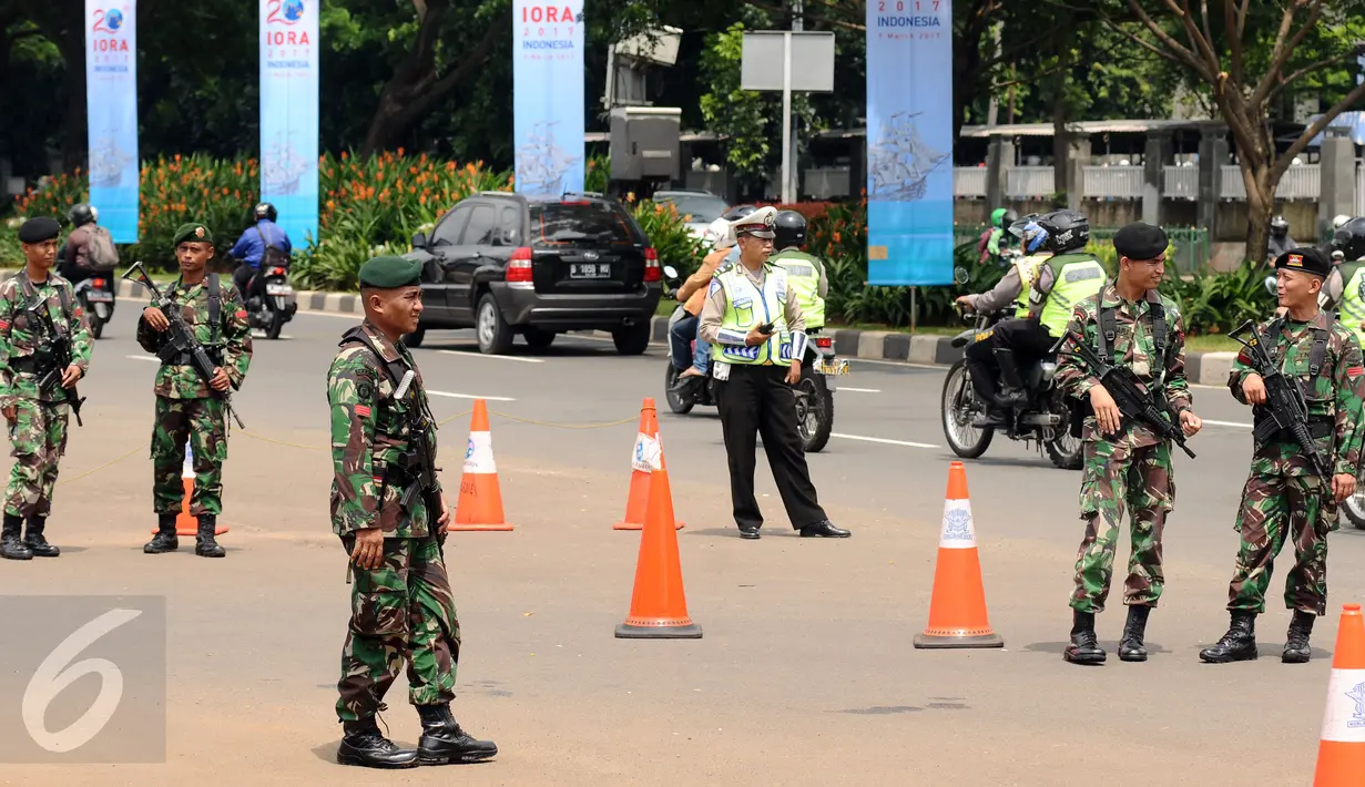 Petugas pengamanan gabungan berjaga di sekitar pintu masuk kawasan Gelora Bung Karno, Jakarta, Senin (6/3). Pengamanan ini terkait pelaksanaan KTT IORA 2017 yang digelar di Jakarta Convention Center 5-7 Maret. (Liputan6.com/Helmi Fithriansyah)