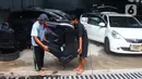 Pekerja mengeluarkan jok mobil yang terkena banjir di bengkel Detailing, Shop, Garage (DSG) di kawasan Pondok Pinang, Jakarta, Kamis (9/1/2020). Biaya yang harus dikeluarkan pemilik mobil berkisar Rp 2 juta hingga Rp 6 juta tergantung tingkat kerusakan kendaraan. (merdeka.com/Arie Basuki)