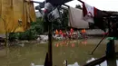 Pasukan oranye memperbaiki tanggul di wilayah Jati Padang, Jakarta, Kamis (30/11). Banjir yang terjadi tersebut akibat tanggul darurat di Kali Pulo jebol karena genangan air yang cukup deras dan membanjiri permukiman sekitar. (Liputan6.com/Johan Tallo)