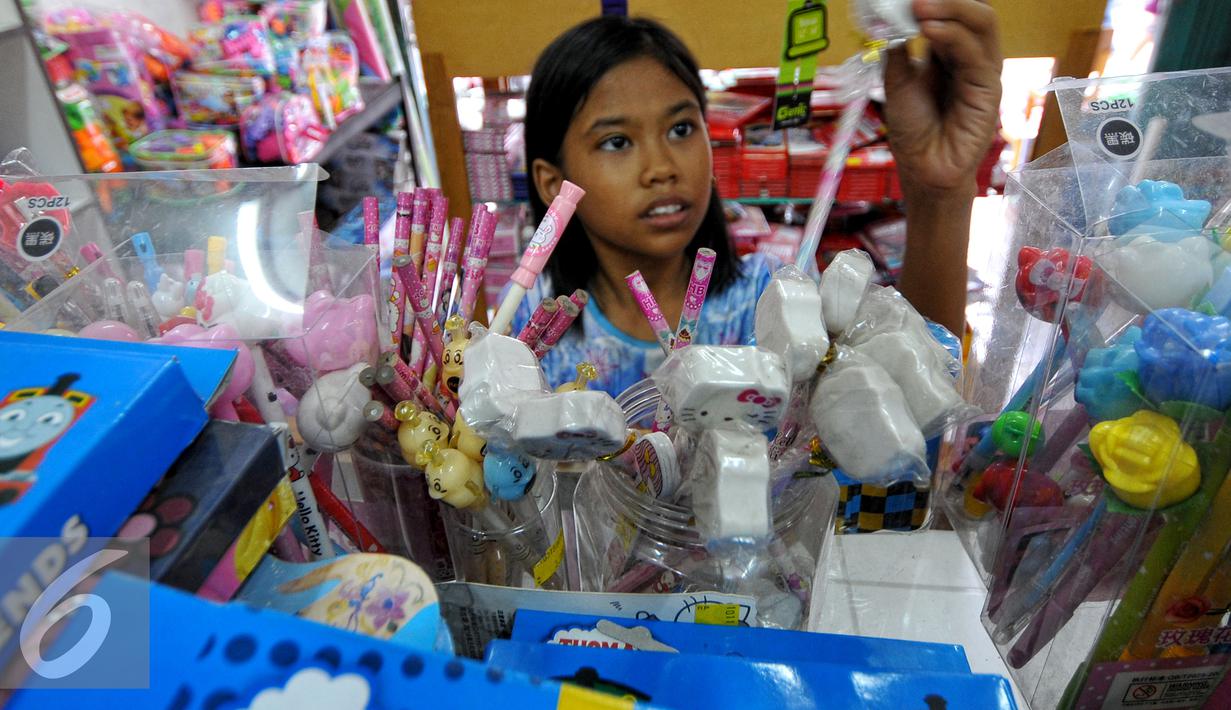 Seorang anak sedang memilih perlengkapan alat tulis sekolah, Jakarta, Minggu (26/7/2015). Jelang tahun ajaran baru 2015/2016, penjualan buku tulis dan perlengkapan sekolah diperkirakan terus meningkat hingga Agustus mendatang. (Liputan6.com/Yoppy Renato)
