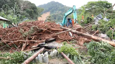 Gambar selebaran yang diambil pada 8 Maret 2023 dan dirilis pada 9 Maret 2023 oleh Badan Penanggulangan Bencana Indonesia ini menunjukkan tim SAR dan alat berat terlihat di lokasi tanah longsor di desa Pangkalan, Natuna, Kepulauan Riau (Kepri). Tim gabungan masih terus mencari puluhan korban hilang pasca tanah longsor yang menimbun satu kampung di Desa Pangkalan. (HO / INDONESIA DISASTER MITIGATION AG / AFP)