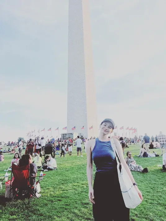 Tampil kasual, Enzy Storia tampak menikmati momennya di Amerika. Dengan tank top biru, Enzy memadukannya dengan celana panjang hitam, menenteng tote bag dan memakai topi hijau. [Foto: Instagram/enzystoria]