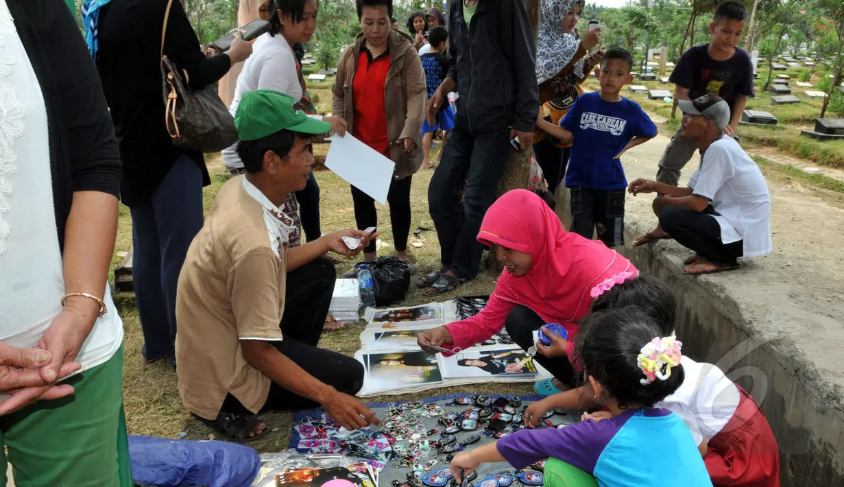 Seorang calon pembeli melihat barang dagangan yang menjual berbagai macam pernak-pernik Olga Syahputra di TPU Malaka, Jakarta, Selasa (31/3/2015). (Liputan6.com/Panji Diksana) 