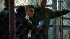 Pelaku penembakan massal di Florida, Nikolas Cruz dikawal petugas saat ditahan, Florida (15/2). Nikolas Cruz melakukan penembakan massal yang menewaskan 17 orang di SMA Majory Stoneman Douglas Florida. (Miguel Guttierez/AFP TV/AFP)