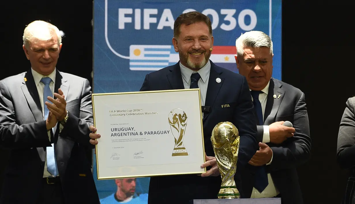 Presiden Paraguay, Alejandro Dominguez (tengah) memegang sertifikat yang mengesahkan Argentina, Paraguay, dan Uruguay sebagai negara tuan rumah Piala Dunia FIFA 2030 selama Kongres virtual FIFA di Luque, Paraguay pada 11 Desember 2024. (AFP/Daniel Duarte)