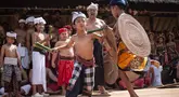 Anak laki-laki mengambil bagian dalam ritual tahunan "Perang Pandan" (pertarungan daun Pandan), yang secara lokal dikenal sebagai "Mekare-kare," untuk menghormati Indra, dewa perang Hindu, di Tenganan Pegringsingan, Bali pada Kamis 11 Juni 2026. (LANA PRIATNA/AFP)