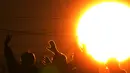 Orang-orang melambai sambil mengamati matahari terbit pertama pada Hari Tahun Baru dari jembatan penyeberangan  di Yokohama dekat Tokyo, Jepang, Minggu (1/1/2023). Masyarakat Jepang umumnya bangun lebih awal untuk menyaksikan matahari terbit pertama pada tahun baru atau pada 1 Januari. (AP Photo/Eugene Hoshiko)