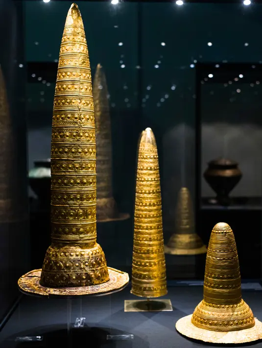Golden Hat of Schifferstadt (kanan) dan dua objek serupa yang ditemukan di Paris dan berasal sekitar 1.300 SM dipajang selama pameran di Museum Martin-Gropius-Bau di Berlin, Jerman (20/9). (AP Photo/Frank Jordans)