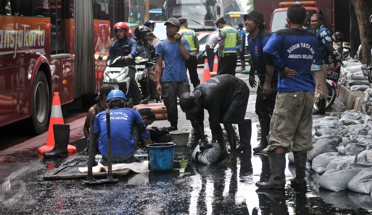 Petugas harian lepas (PHL) dari Sudin Sumber Daya Air dikerahkan untuk membersihkan saluran di Jalan Gatot Subroto, Jakarta, Jumat (10/3). Pembersihan dilakukan karena di kawasan ini banjir selalu datang saat hujan turun. (Liputan6.com/Yoppy Renato)