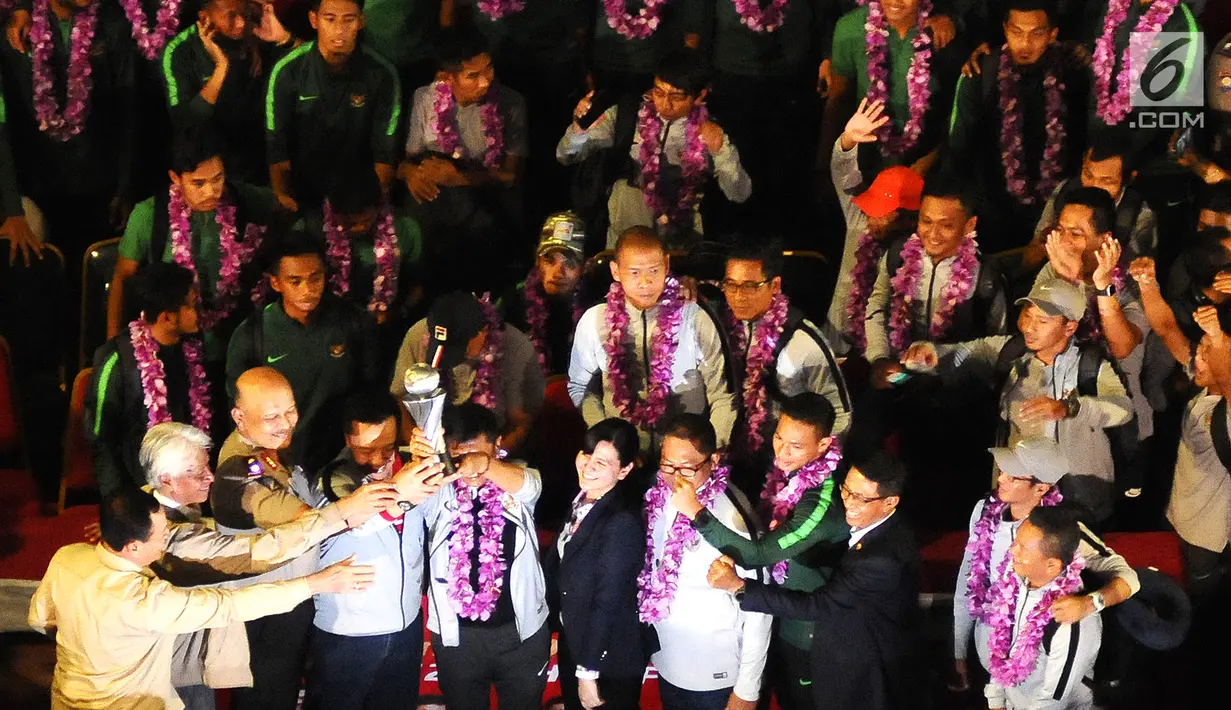 Menpora Imam Nahrawi, Pelatih Indra Sjafri, Sekjen PSSI Ratu Tisha Destria dan para pemain Timnas Indonesia U-22 foto bersama dengan mengangkat Piala AFF U-22 2019 di Bandara Soekarno Hatta, Tangerang, Rabu (27/2). (Liputan6.com/Herman Zakharia)