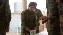 Seorang prajurit perempuan Yazidi dari Unit Perlawanan Sinjar (YBS) membuat air minum untuk rekan-rekannya saat beristirahat di sebuah kamp di wilayah Pegunungan Sinjar, Irak (6/6). (Reuters/Stringer)