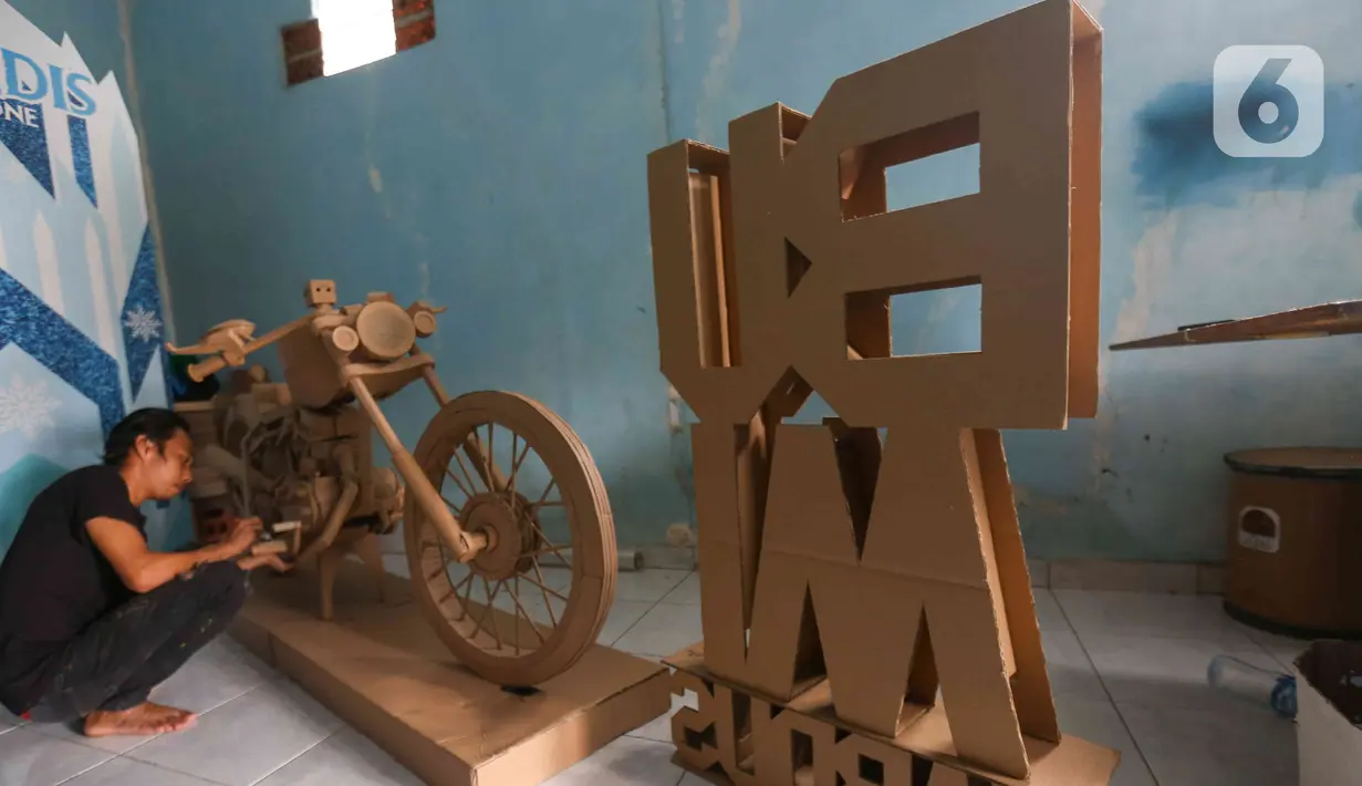 Perajin menyelesaikan pembuatan motor dari kardus di Workshop Bumi Kardus, Depok, Jawa Barat, Jumat (15/7/2022). Kerajinan berbahan baku kardus tersebut dijual dengan harga Rp 400 ribu hingga Rp 60 juta tergantung tingkat kesulitan dan ukuran. (Liputan6.com/Herman Zakharia)