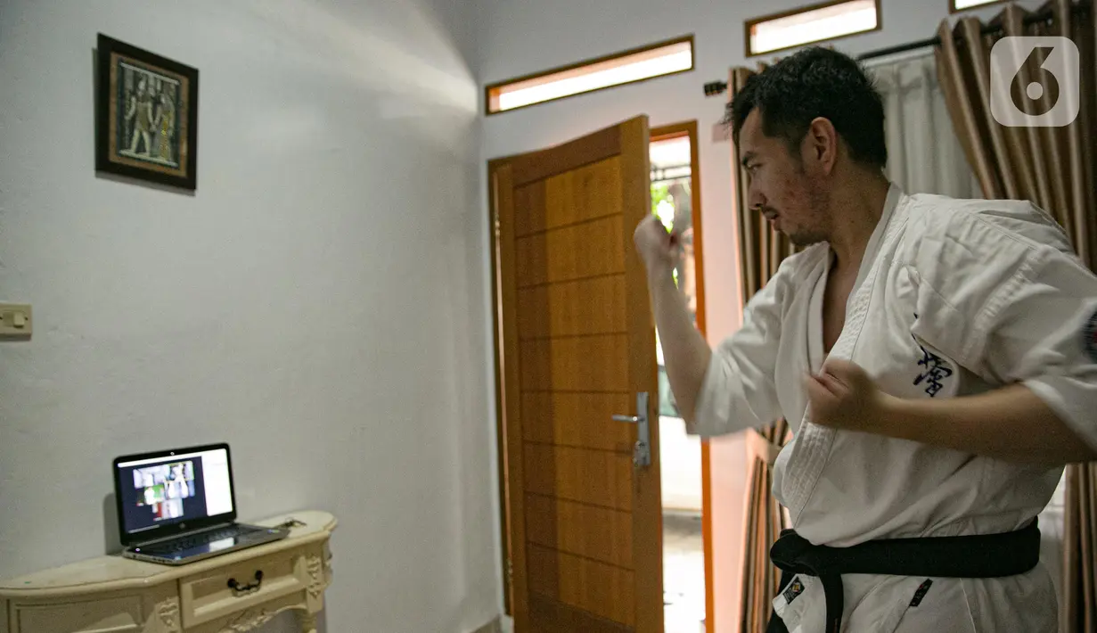 Charlie (28) instruktur karate mengajar murid secara virtual di Jakarta, Sabtu (13/2/2021). Sejak bulan Maret murid-murid berlatih di rumah secara vitual guna mencegah penyebaran virus Covid-19. (Liputan6.com/Faizal Fanani)