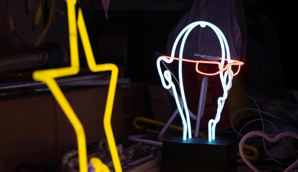 Salah satu karyanya Wu Chi-kai terlihat selama wawancara dengan AFP di Hong Kong (16/4). Wu Chi-kai merupakan salah satu pengrajin neon sign yang tersisa dari jenisnya di Hong Kong. (AFP Photo/Philip Fong)