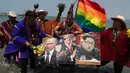 Sekelompok dukun memegang poster Presiden AS Donald Trump, Pemimpin Korut Kim Jong-un, Vladimir Putin dan Presiden Meksiko Andres Manuel Lopez Obrador selama ritual untuk menyambut tahun baru  di pantai Agua Dulce, Lima, Kamis (27/12). (AP/Martin Mejia)