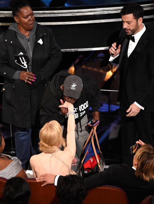 Seorang turis mencium tangan aktris Nicole Kidman selama perhelatan Academy Awards ke-89, di California, Minggu (26/2). Oscar tahun ini mendapat kejutan dengan kedatangan para turis yang diajak masuk oleh host Jimmy Kimmel. (Chris Pizzello/Invision/AP)