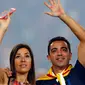 Gelandang Barcelona, Xavi Hernandes bersama istrinya menyapa pengemarnya saat parade di stadion Camp Nou, Spanyol (7/6/2015). ini merupakan musim terakhir Xavi berkostum Barcelona yang akan pindah ke klub papan atas Qatar, Al Sadd. (REUTERS/Albert Gea)