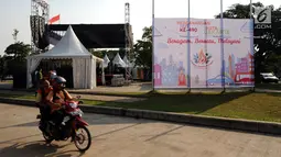 Warga melintasi area Konser Kebangkitan Nasional dan Pencanangan HUT Jakarta ke 490 di Taman Kota Waduk Pluit, Jakarta, Jumat (19/5). HUT Jakarta ke 490 mengambil tema Beragam, Bersatu dan Melayani. (Liputan6.com/Helmi Fithriansyah)