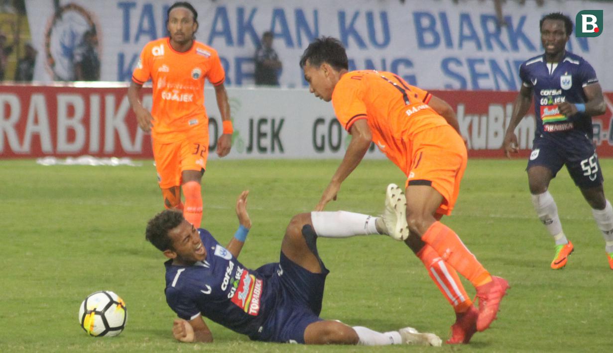 Striker PSIS Semarang, Hari Nur Yulianto, dijatuhkan gelandang Persija Jakarta, Novri Setiawan, pada laga Liga 1 di Stadion Sultan Agung, Bantul, Jumat (20/4/2018). PSIS kalah 1-4 dari Persija. (Bola.com/Ronald Seger)