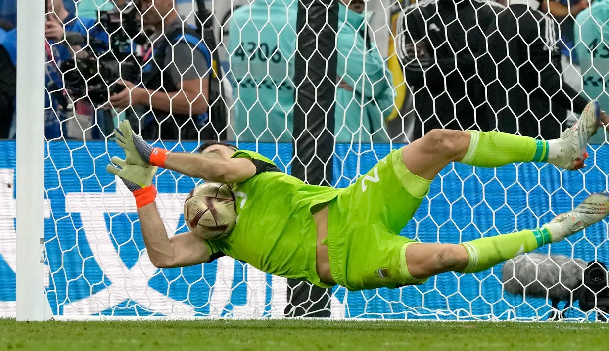 Kiper Argentina Emiliano Martinez memblokir tendangan saat adu penalti melawan Prancis pada pertandingan sepak bola final Piala Dunia 2022 di Stadion Lusail, Lusail, Qatar, 18 Desember 2022. Bermain imbang 3-3 selama 120 menit, Prancis akhirnya tumbang 2-4 dari Argentina dalam drama adu penalti. (AP Photo/Frank Augstein)