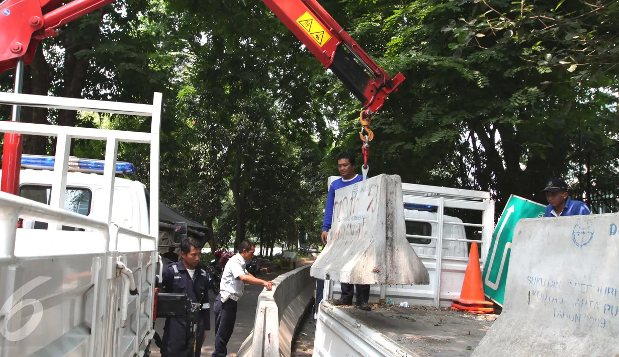 Petugas Dishub membongkar beton pembatas Jalan M. Yamin di depan bekas gedung Kedubes Inggris, Jakarta, Kamis (17/9/2015). Pembongkaran dilakukan karena beton tersebut akan dipergunakan di tempat lain. (Liputan6.com/Angga Yuniar)