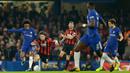 Pemain Chelsea, Willian menggiring bola dengan kawalan pemain Bournemouth, Harry Arter pada laga perempat final, di Stadion Stamford Bridge, Kamis (21/12). Chelsea berhasil mengalahkan Bournemouth dengan susah payah 2-1. (AP/Alastair Grant)