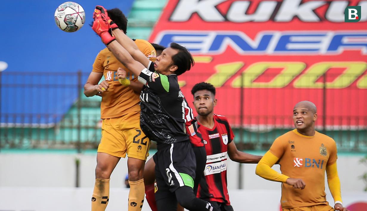 Kiper Bhayangkara FC, Awan Setho (tengah) berusaha menghalau bola saat menghadapi Persipura Jayapura dalam laga pekan ke-15 BRI Liga 1 2021/2022 di Stadion Moch. Soebroto, Magelang, Kamis (02/12/2021). (Bola.com/Bagaskara Lazuardi)