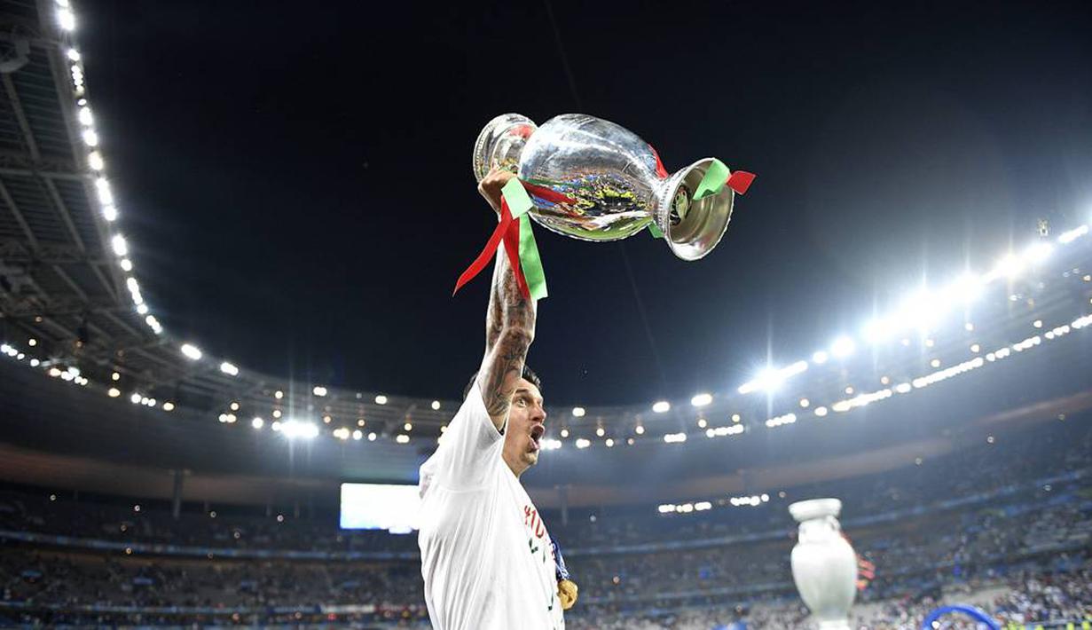Bek Portugal, Fonte, mengangkat trofi juara Piala Eropa 2016, Senin (11/7/2016) dini hari WIB. (AFP/Martin Bureau)