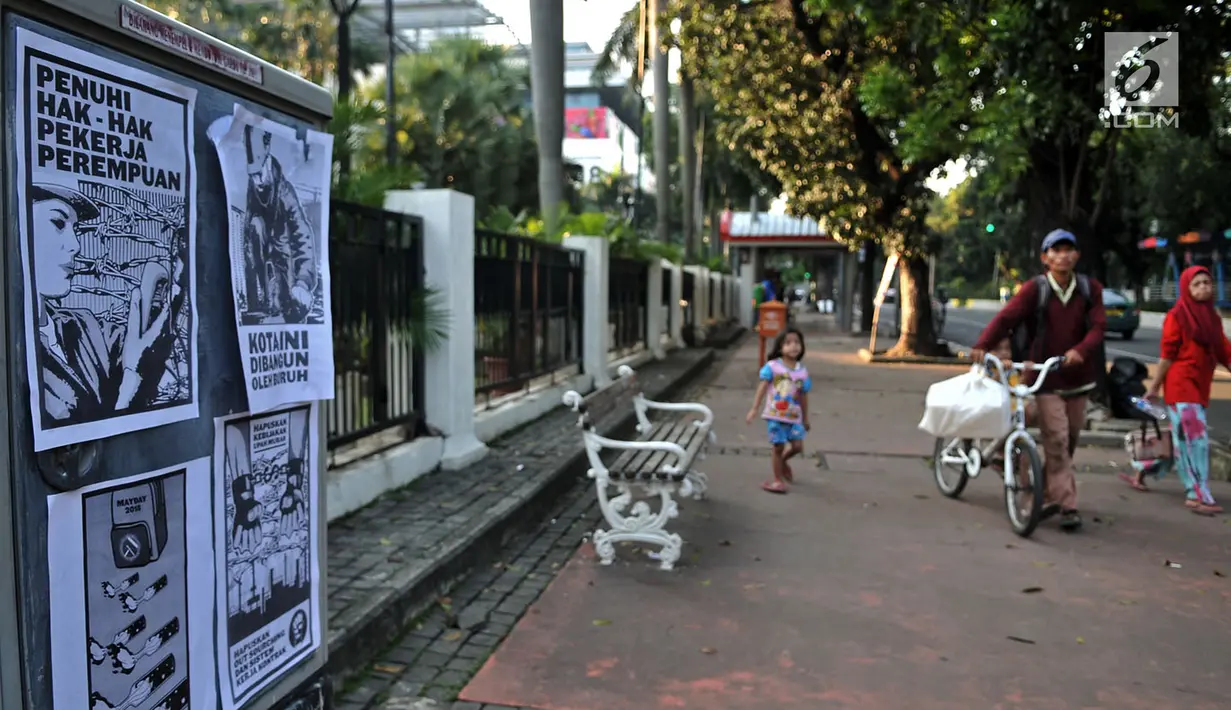 Poster tuntutan buruh terlihat di Jalan Merdeka Barat, Jakarta, Selasa (1/5). Aksi May Day di Jakarta meninggalkan jejak vandalisme yang dibuat kaum pekerja itu. (Merdeka.com/ Iqbal S. Nugroho)