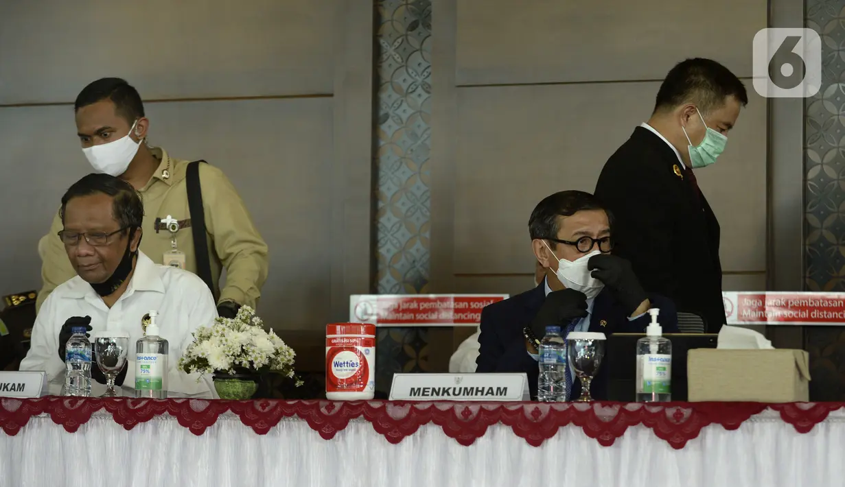 Menko Polhukam Mahfud MD (kiri) dan Menkumham Yasonna H Laoly saat menyampaikan keterangan terkait pemulangan buron Maria Pauline Lumowa di Bandara Soetta, Tangerang, Banten, Kamis (9/7/2020). Maria merupakan pembobol kas BNI Cabang Kebayoran Baru senilai Rp 1,2 triliun. (merdeka.com/Dwi Narwoko)