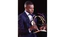 Ekspresi pemain PSG, Kylian Mbappe saat mendapatkan penghargaan pemain terbaik Ligue1 Prancis pada acara yang berlangsung di Paris, Prancis, Senin (13/04/2024) waktu setempat. (AFP/Franck Fife)