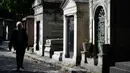 Seorang pria berjalan melewati kuburan di pemakaman Pere Lachaise di Paris (22/7/2019). Pemakaman ini paling banyak didatangi wisatawan di dunia. Artis dan banyak tokoh terkenal dimakamkan di sini. (AFP Photo/Philippe Lopez)