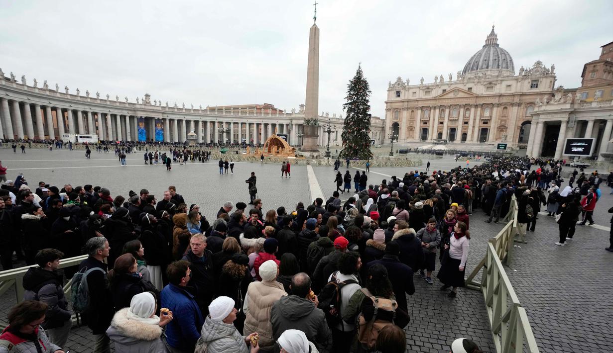 Orang-orang mengantre untuk memasuki Basilika Santo Petrus tempat mendiang Paus Emeritus Benediktus XVI disemayamkan di Vatikan, Senin (2/1/2023). Benediktus XVI, teolog Jerman yang akan dikenang sebagai paus pertama dalam 600 tahun yang mengundurkan diri, telah meninggal pada 31 Desember 2022 di usia 95 tahun. (AP Photo/Alessandra Tarantino)