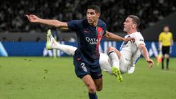 Paris Saint-Germain, Achraf Hakimi (kiri) berebut bola dengan pemain Inter Milan, Robin Gosens saat laga uji coba pramusim di Japan National Stadium, Tokyo, Jepang, Selasa (01/08/2023). (AFP/Richard A. Brooks)