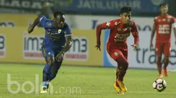 Gelandang Persib Bandung, Michael Essien dan Gelandang Arema FC, Hanif Sjahbani berusaha mengejar bola. Dalam pertandingan tersebut, Essien turun sebagai starter hingga digantikan Dedi Kusnandar di pertengahan babak kedua. (Bola.com/M Iqbal Ichsan).