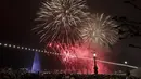 Kembang api menerangi langit di teluk di sebelah air mancur terkenal Le Jet d'Eau selama perayaan Tahun Baru di Jenewa, Swiss, Rabu (1/1/2020). (Salvatore Di Nolfi / Keystone via AP)