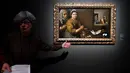 Seorang pemandu memberi penjelasan tentang lukisan Kristus di rumah Marta dan Maria (1618) karya pelukis Spanyol Diego Velezquez (1599-1660) saat pameran 'Spanish Still Life' di Pusat Seni Rupa BOZAR, Brussels, Belgia, Jumat (22/2). (AFP PHOTO/JOHN THYS)