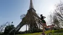 Seorang pengunjung berolahraga sambil menikmati musim semi yang hangat dan cerah di dekat menara Eiffel, Paris, Kamis (9/4/2015). (REUTERS/Gonzalo Fuentes)