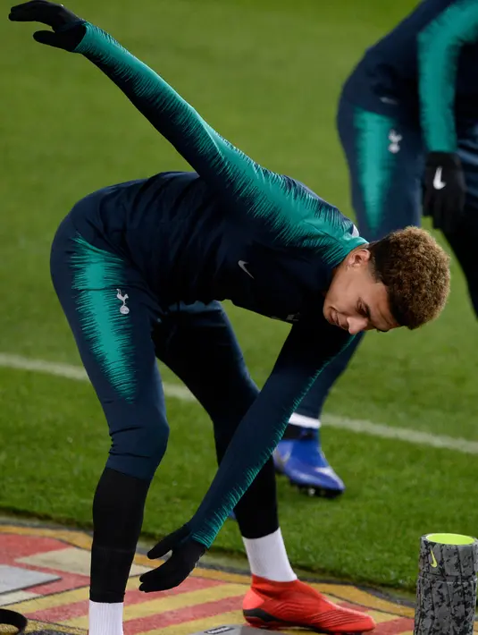 Gelandang Tottenham Hotspur, Dele Alli melakukan pemanasan selama latihan di stadion Camp Nou, Barcelona (10/12). Tottenham akan melakoni laga penentuan melawan Barcelona pada grup B Liga Champions. (AFP Photo/Josep Lago)