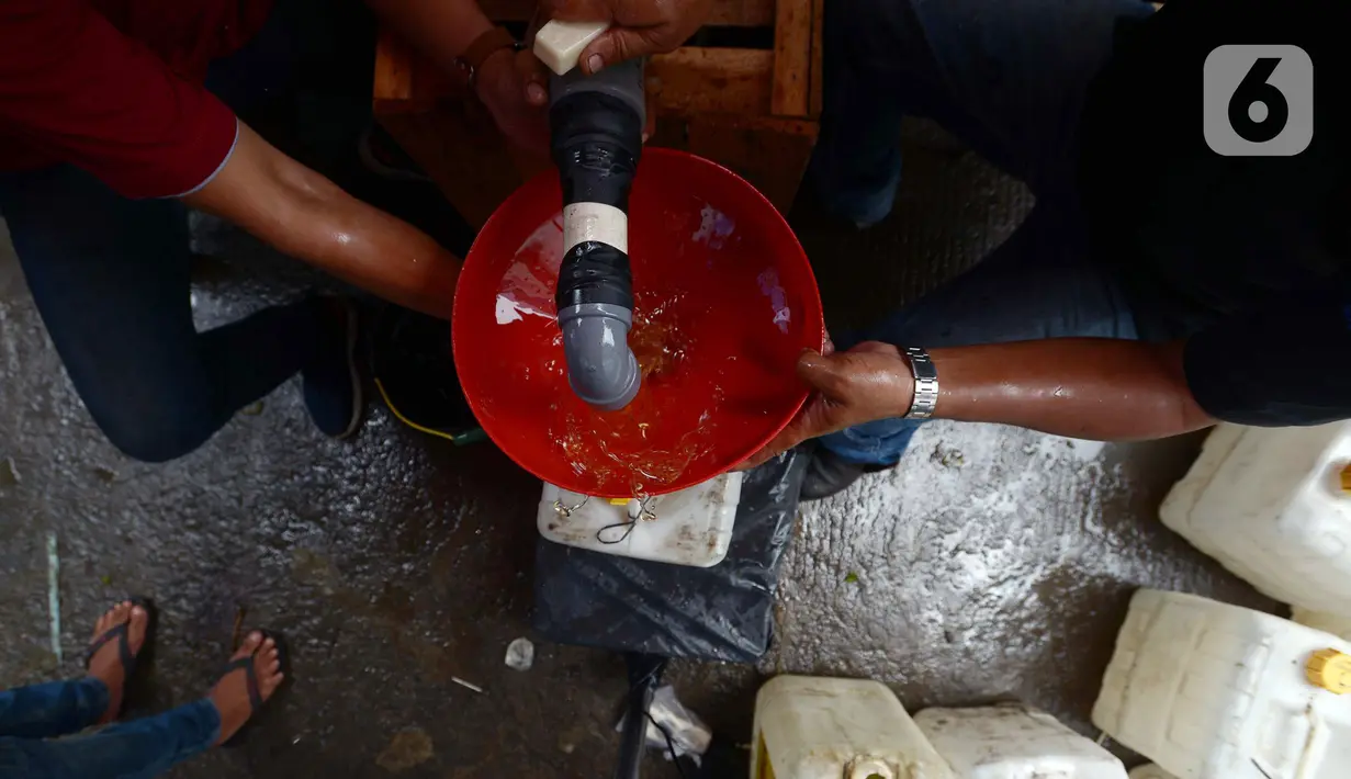 Distribusi minyak goreng curah di Pasar Perumnas, Jumat (25/2/2022). Langkah cepat dalam mengisi pasokan ke pasar-pasar diharapkan bisa menstabilkan harga minyak goreng curah yang ditetapkan pemerintah sebesar Rp 11.500 per liter. (merdeka.com/Imam Buhori)
