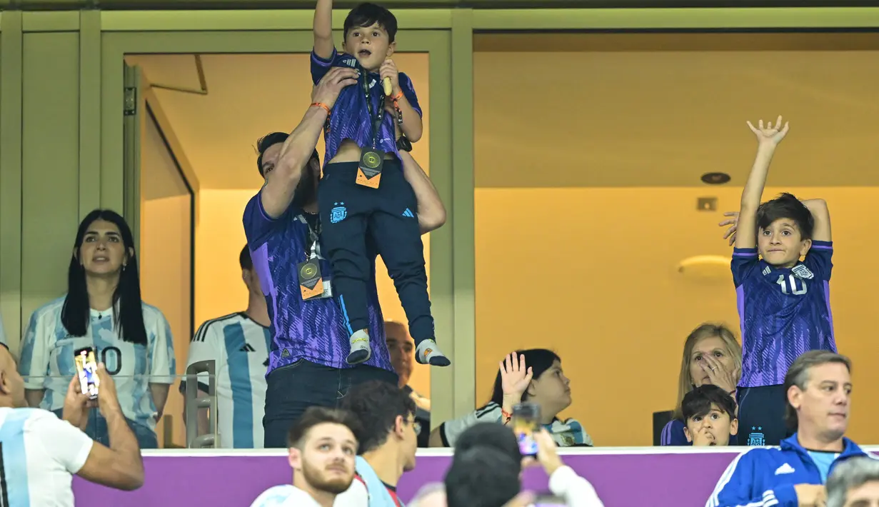 Putra penyerang Argentina Lionel Messi, Thiago dan Ciro menunggu jelang pertandingan semifinal Piala Dunia Qatar 2022 antara Argentina dan Kroasia di Stadion Lusail di Lusail, Doha, Rabu (14/12/2022). Argentina menang atas Kroasia 3-0. (AFP/Juan Mabromata)